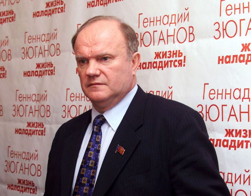 &copy; Reuters. Russian Communist Party leader Gennady Zyuganov stands in front of posters carrying his name and the words: ''Life will get better'' in his headquarters in Moscow March 26. [Partial returns from Russia's presidential election show that Acting President Vl