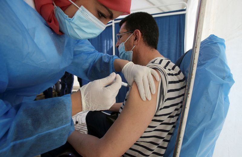 &copy; Reuters. أحد العاملين بالرعاية الصحية يحصل على تطعيم ضد كوفيد-19 في العاصمة الجزائر يوم السادس من يونيو حزيران 2021. تصوير: رمزي بودينا - رويترز.