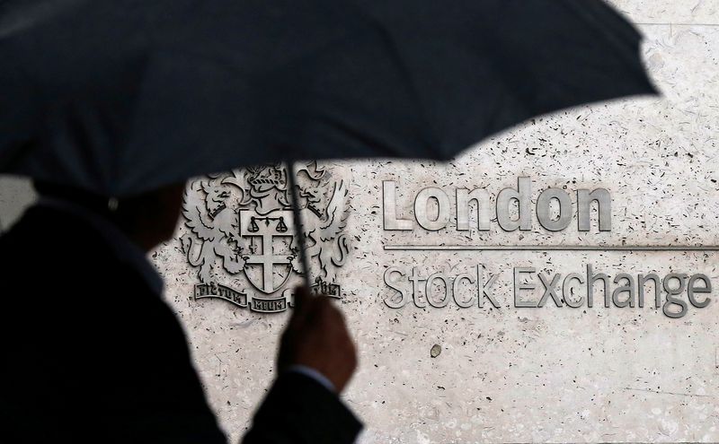 &copy; Reuters. FILE PHOTO: A man shelters under an umbrella as he walks past the London Stock Exchange in London, Britain, August 24, 2015. REUTERS/Suzanne Plunkett/