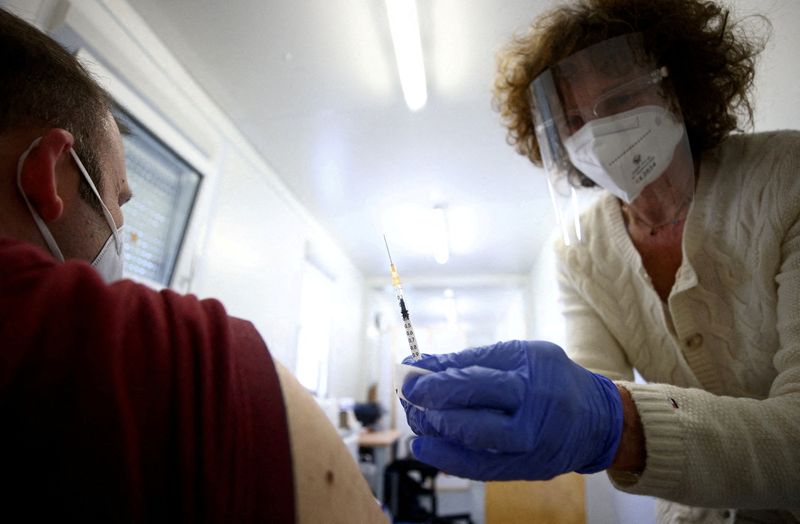 &copy; Reuters. FOTO DE ARCHIVO: Un médico vacuna a una persona con una dosis de la vacuna COVID-19 de Pfizer-BioNTech en Viena, Austria 26 de abril de 2021. REUTERS/Lisi Niesner
