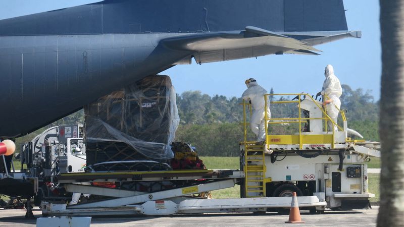 © Reuters. Personnel wearing personal protection equipment (PPE), and a load of humanitarian relief supplies sent by New Zealand are seen next to an aircraft at Fua?amotu International Airport on the island of Tongatapu, Tonga, January 20, 2022 in this picture obtained from social media. New Zealand High Commission, Nuku'alofa Tonga/via REUTERS 