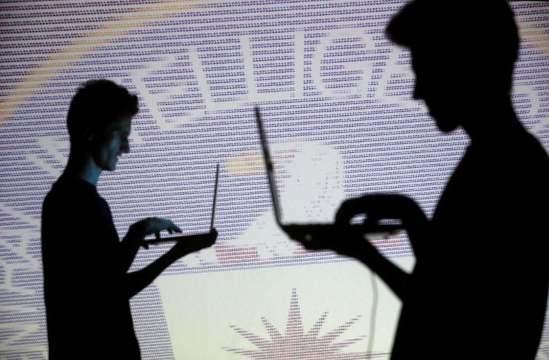 &copy; Reuters. Imagen de archivo ilustrativa de siluetas de personas posando con laptops frente a una pantalla que proyecta código binario y el emblema de la Agencia Central de Inteligencia (CIA) tomada en Zenica el 29 de octubre de 2014. REUTERS/Dado Ruvic/Ilustració