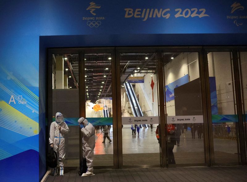 &copy; Reuters. Foto del miércoles de trabajadores con trajes especiales contra el COVID-19 fuera del centro de prensa de los Juegos de Invierno de Pekín. 
Ene 19, 2022.    REUTERS/Fabrizio Bensch