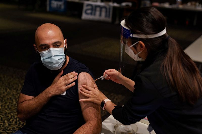 &copy; Reuters. FOTO DE ARCHIVO: Una enfermera administra una dosis de la vacuna de COVID-19 a un hombre en Sídney, Australia, el 25 de agosto de 2021. REUTERS/Loren Elliott