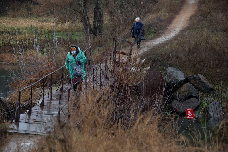 &copy; Reuters. FILE PHOTO: Women walk in the village of Staromarivka located on the separation line that divides Ukraine between government-controlled territory and the enclave controlled by Russian-backed separatist forces, in Donetsk Region, Ukraine November 23, 2021.