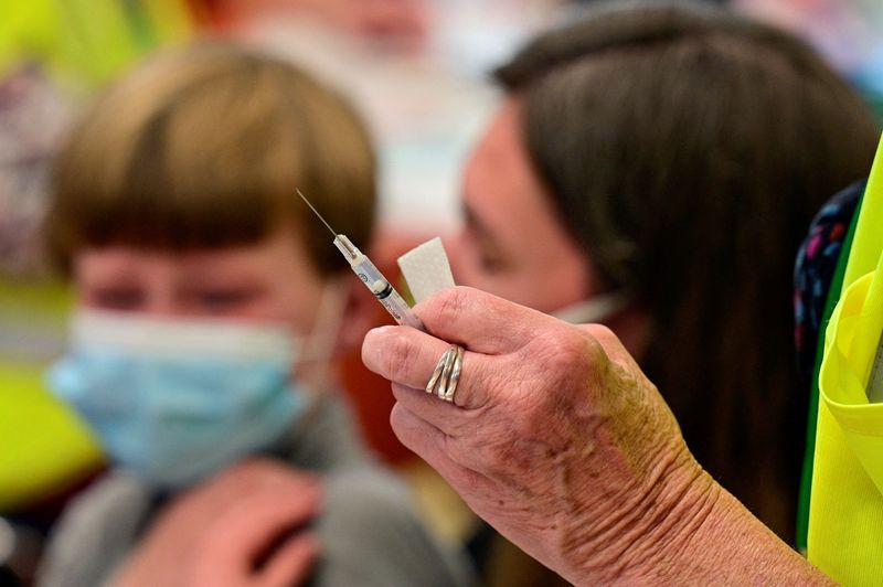 © Reuters. FILE PHOTO: A child is seen near a syringe containing a dose of the Pfizer-BioNTech coronavirus disease (COVID-19) vaccine at Smoketown Family Wellness Center in Louisville, Kentucky, U.S., November 8, 2021. REUTERS/Jon Cherry/File Photo