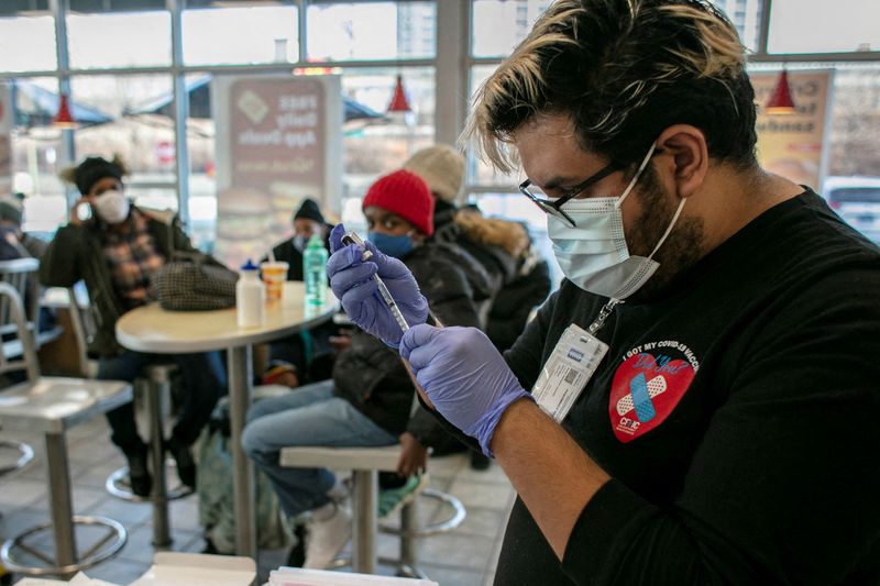 &copy; Reuters. IMAGEN DE ARCHIVO REFERENCIAL. Un trabajador del Chicago Family Health Center prepara un refuerzo de la vacuna contra el COVID-19, en un McDonald's, en Chicago, EEUU, Diciembre 21, 2021. REUTERS/Jim Vondruska