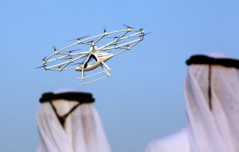 &copy; Reuters. رجلان ينظران إلى تاكسي طائر في دبي بالإمارات العربية المتحدة. صورة من أرشيف رويترز.