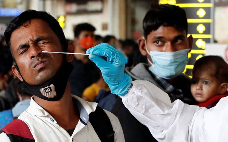 &copy; Reuters. أحد العاملين في القطاع الطبي يأخذ مسحة من رجل لاختبار إصابته بفيروس كورونا في محطة سكة حديد بمومباي يوم 13 يناير كانون الثاني 2022. تصوير: فرانس