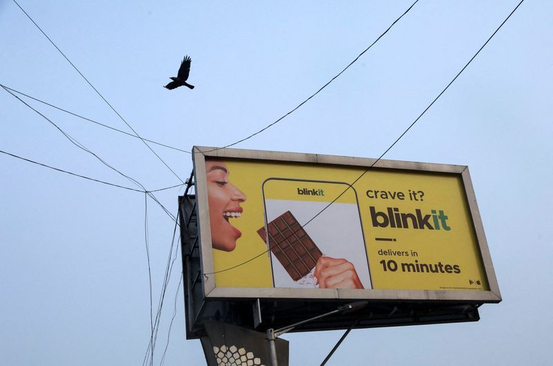 © Reuters. A bird flies over a hoarding featuring an advertisement of the SoftBank-funded Blinkit, an Indian company which is offering 10 minute deliveries for groceries, in New Delhi, India, January 20, 2022. Picture taken on January 20, 2022. REUTERS/Anushree Fadnavis