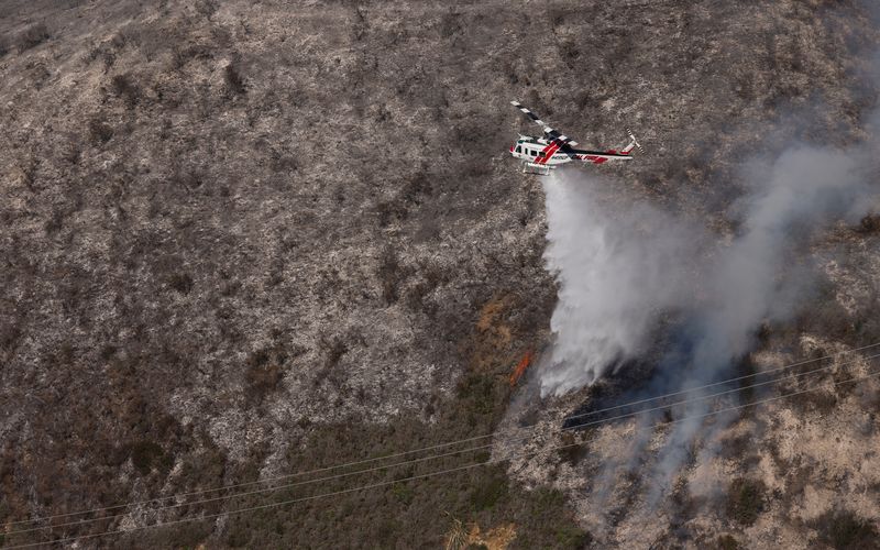 &copy; Reuters. طائرة تحاول إخماد حريق شب بالقرب من منطقة بيج سور الجبلية في ولاية كاليفورنيا الأمريكية يوم السبت. تصوير: بيتر دا سيلفا - رويترز. 