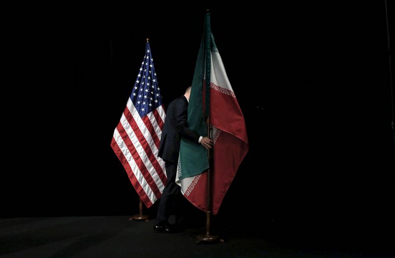 &copy; Reuters. FILE PHOTO: A staff member removes the Iranian flag from the stage after a group picture with foreign ministers and representatives of United States, Iran, China, Russia, Britain, Germany, France and the European Union during the Iran nuclear talks at the