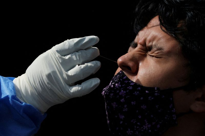 &copy; Reuters. أحد العاملين في القطاع الصحي يأخذ مسحة من رجل لاختبار الإصابة بفيروس كورونا في مكسيكو سيتي يوم 20 يناير كانون الثاني 2022. تصوير: إدجارد جاريدو 