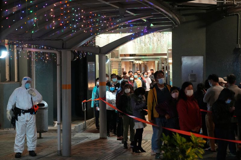 &copy; Reuters. A health worker wearing a protective suit stands as residents queue for taking nucleic acid test for the coronavirus disease (COVID-19) at a makeshift testing site, after the government announced that several residential buildings to be locked down at Kwa