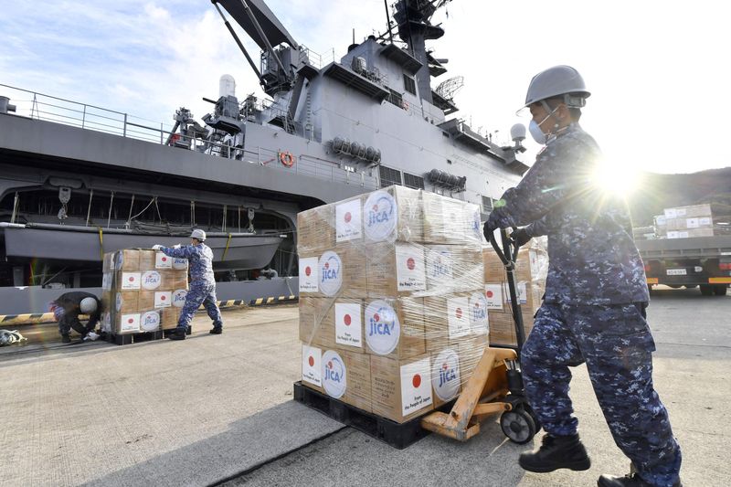 © Reuters. Japan Self-Defense Forces officers load relief supplies bound for Tonga onto the Japan Maritime Self-Defense Force's transport vessel Osumi at its base in Kure, Hiroshima Prefecture, Japan January 24, 2022, in this photo taken by Kyodo. Mandatory credit Kyodo/via REUTERS 