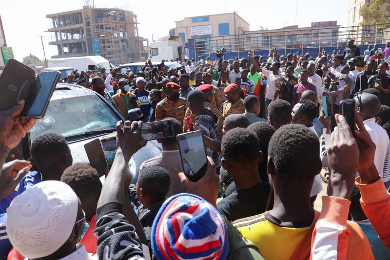 &copy; Reuters. مواطنون محتشدون حول سيارة تابعة للرئاسة في بوركينا فاسو بعد أنباء عن اجتجاز الجيش للرئيس كابوري وبعد إطلاق نار كثيف قرب مقر الإقامة الرئاسي
