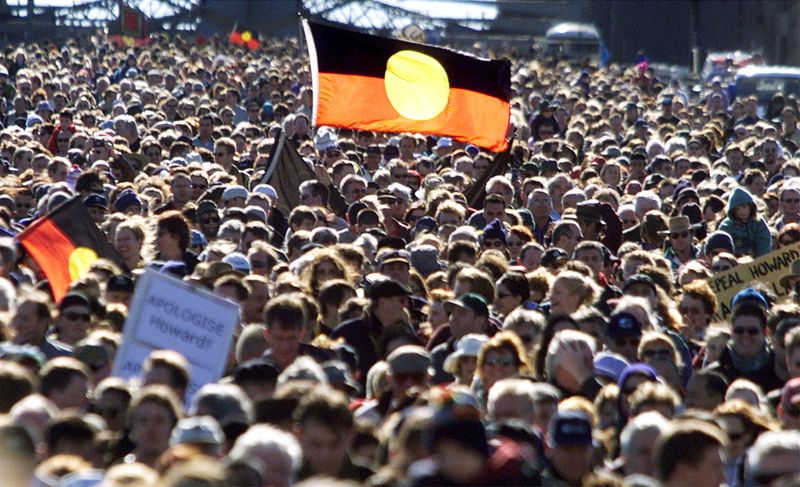 &copy; Reuters. FILE PHOTO: Aboriginal flags rise above a crowd walking across Sydney Harbour Bridge on May 28, 2000. DG/PB/File Photo