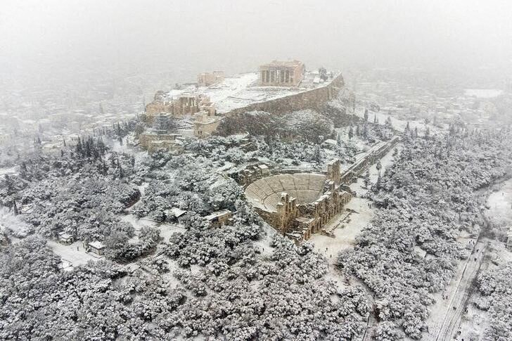 &copy; Reuters. 　１月２４日、大雪に無縁なはずのギリシャの首都アテネが、２年連続の豪雪に見舞われ、公共交通機関が停止し、航空便も欠航が相次いだ。写真はアクロポリスの丘とパルテノン神殿（２