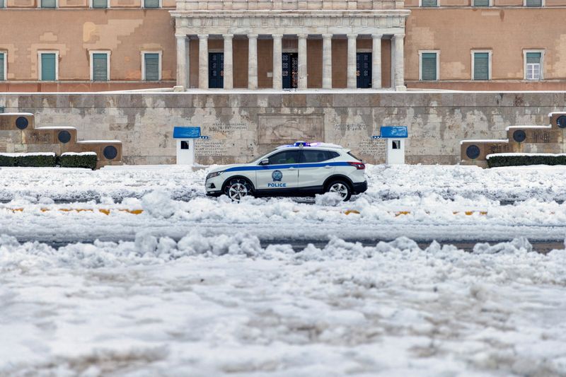 &copy; Reuters. سيارة شرطة تسير أمام البرلمان في أثينا يوم الثلاثاء بعد تساقط كثيف للثلوج. تصوير: أليكس قنسطنطنيدس - رويترز.
