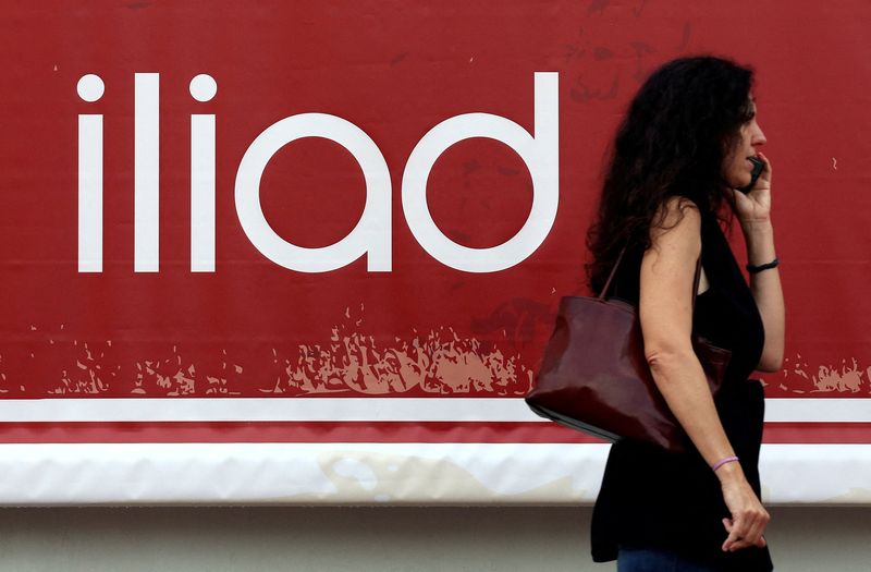 &copy; Reuters. Una donna al telefono di fronte ad un logo Iliad a Milano. 29 maggio 2018  REUTERS/Stefano Rellandini