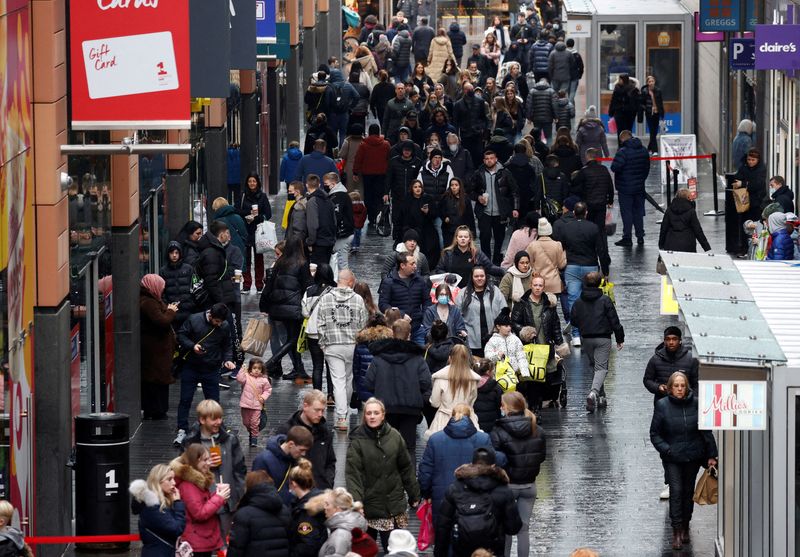 &copy; Reuters. FILE PHOTO: People walk along a busy shopping street as people look for bargains in the traditional Boxing Day sales in Liverpool, Britain, December 26 , 2021. REUTERS/Phil Noble/File Photo