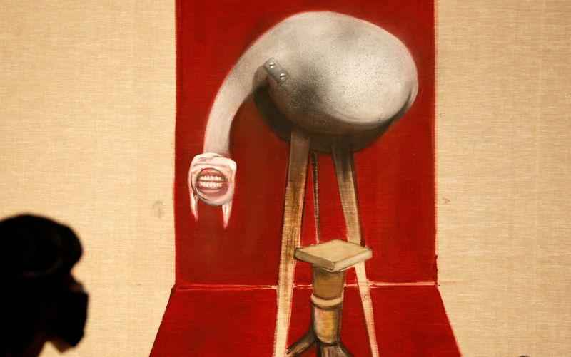 &copy; Reuters. Un miembro del personal de la Royal Academy of Arts posa con " Segunda versión del tríptico 1944", 1988, de Francis Bacon en Londres, Reino Unido, el 25 de enero de 2022.  REUTERS/Peter Cziborra