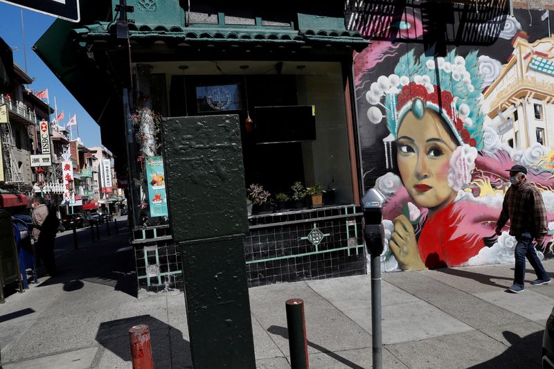 &copy; Reuters. FILE PHOTO: A man wearing a face mask walks through Chinatown, a day after California's Governor Gavin Newsom implemented a statewide "stay at home order" directing the state's nearly 40 million residents to stay in their homes for the foreseeable future 