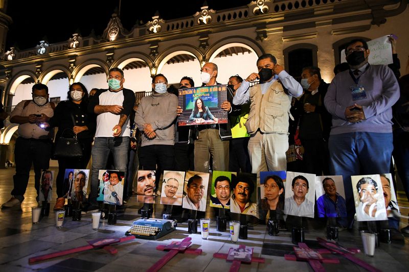 © Reuters. Mexican journalists gather around pictures of colleagues who have been murdered as they protest the recent killings of photojournalist Margarito Martinez and journalist Lourdes Maldonado, in Veracruz, Mexico January 25, 2022. REUTERS/Yahir Ceballos