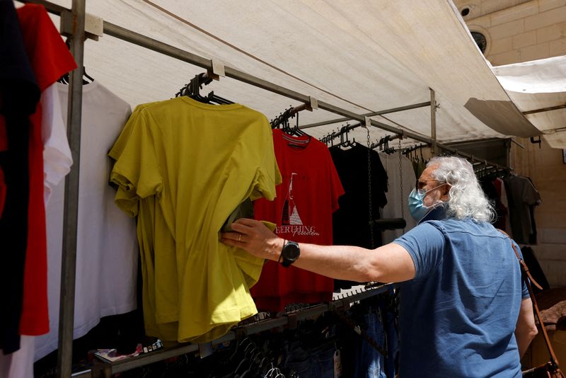 &copy; Reuters. FOTO DE ARCHIVO: Un hombre con mascarilla mira camisetas en un mercadillo de La Valeta, Malta, el 10 de mayo de 2021. REUTERS/Darrin Zammit Lupi