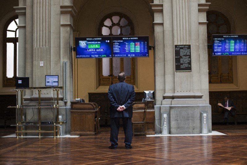 &copy; Reuters. FOTO DE ARCHIVO: Un hombre contempla varios paneles electrónicos con datos de cotización en el interior de la Bolsa de Madrid, España, el 29 de junio de 2012.