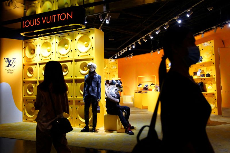&copy; Reuters. FILE PHOTO: Customers wearing face masks following the COVID-19 outbreak walk past a store of French luxury brand Louis Vuitton inside a shopping mall in Beijing, China September 19, 2020.   REUTERS/Tingshu Wang/File Photo  GLOBAL BUSINESS WEEK AHEAD