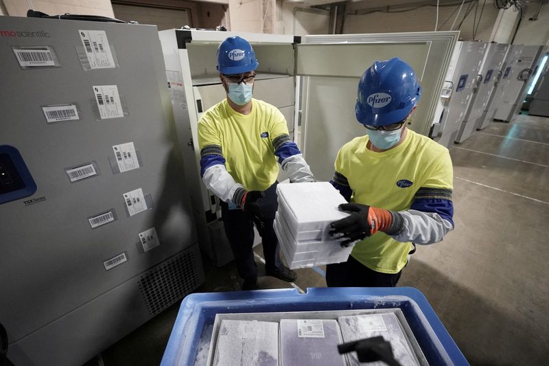 &copy; Reuters. Imagen de archivo dos trabajadores preparando cajas que contienen la vacuna contra el COVID-19 elaborada por Pfizer-BioNTech para ser enviadas desde la planta de manufactura Pfizer Global Supply Kalamazoo en Portage, Michigan, Estados Unidos. 13 de diciem