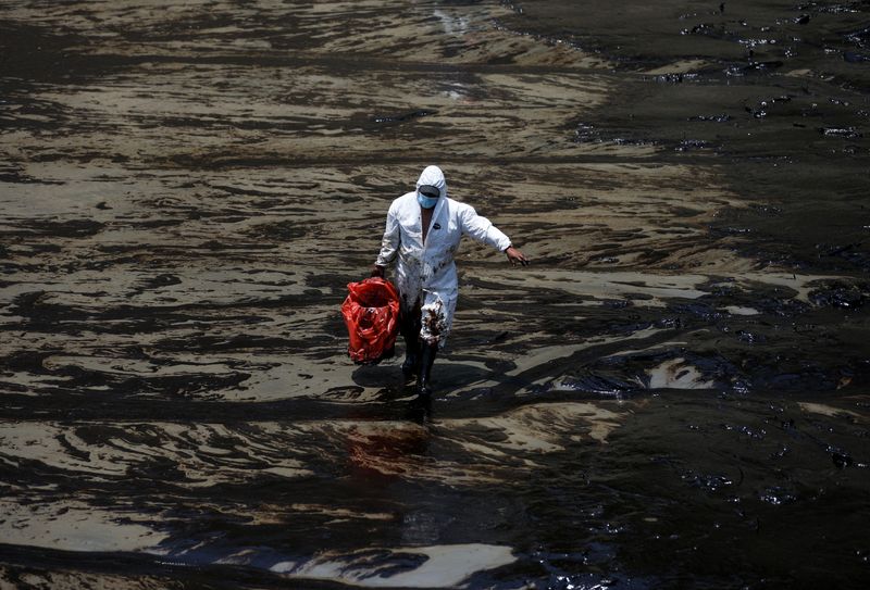 &copy; Reuters. Um trabalhador caminha em meio a um derramamento de petróleo causado por ondas anormais, provocadas pela erupção vulcânica em Tonga. REUTERS/Pilar Olivares