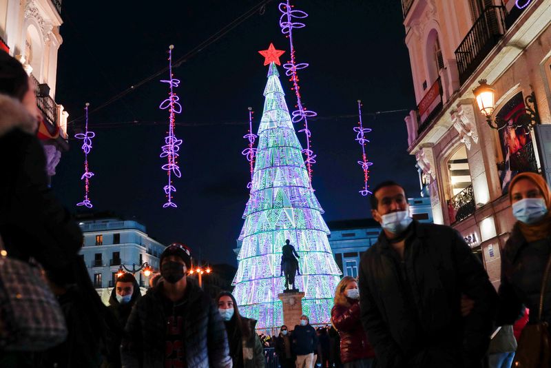 &copy; Reuters. FOTO DE ARCHIVO: Varias personas con mascarillas pasean bajo las luces de Navidad en la Puerta del Sol de Madrid, España, el 8 de diciembre de 2021. REUTERS/Susana Vera