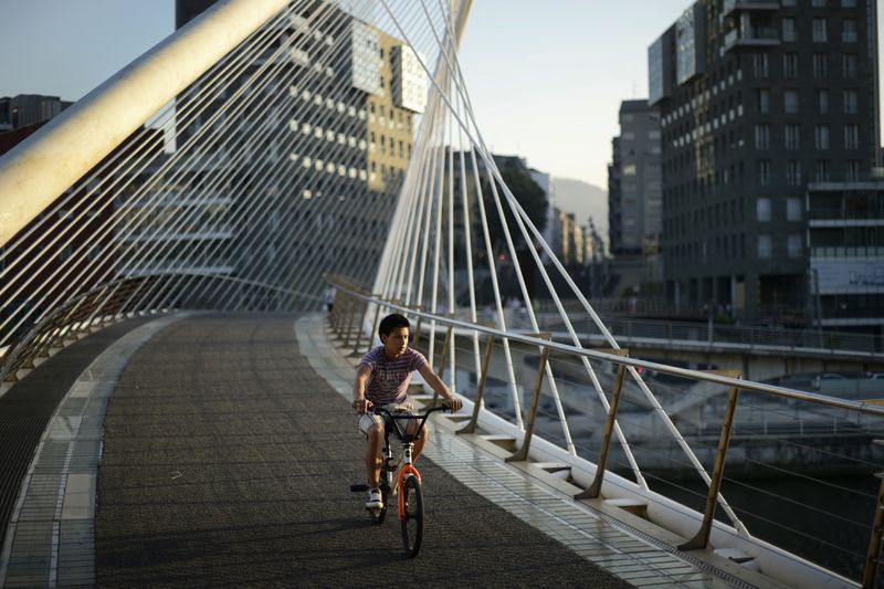 &copy; Reuters. FOTO DE ARCHIVO-Un niño cruza en bicicleta la pasarela peatonal de Zubizuri (Puente Blanco) en Bilbao. 26 de junio de 2012. REUTERS/Vincent West