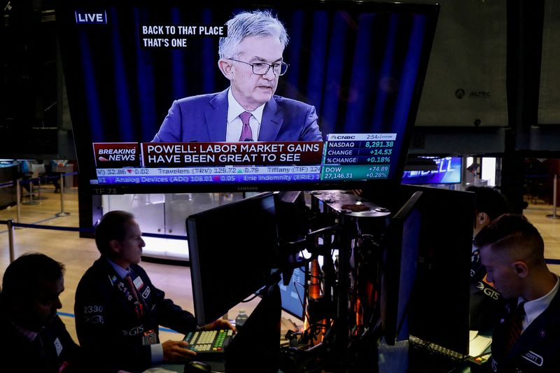 &copy; Reuters. FOTO DE ARCHIVO: Operadores trabajan, mientras una pantalla muestra la conferencia de prensa del presidente de la Reserva Federal, Jerome Powell, en el piso de la Bolsa de Valores de Nueva York (NYSE) en Nueva York, Estados Unidos. 30 de octubre de 2019. 