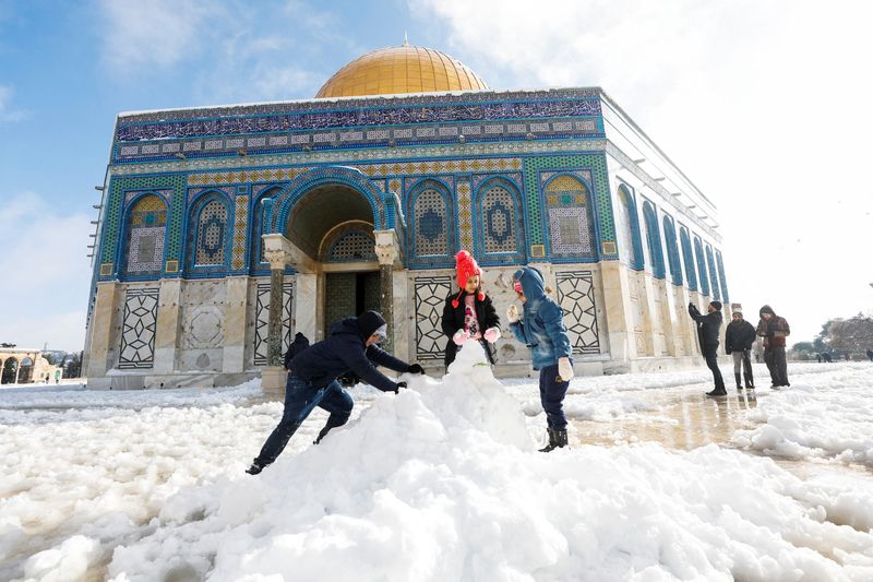 &copy; Reuters. Niños arman un muñeco de nieve frente a la Cúpula de la Roca, ubicada en la Ciudad Vieja de Jerusalén en el recinto conocido por los musulmanes como Santuario Noble y por los judíos como Templo del Monte, durante una mañana nevada en la Ciudad Vieja