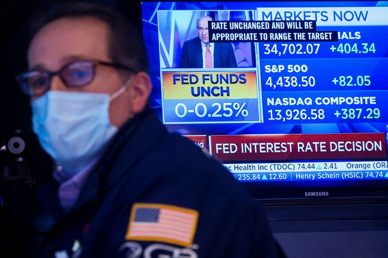 © Reuters. A screen displays the Fed rate announcement as a specialist trader works at his post on the floor of the New York Stock Exchange (NYSE) in New York City, U.S., January 26, 2022.  REUTERS/Brendan McDermid