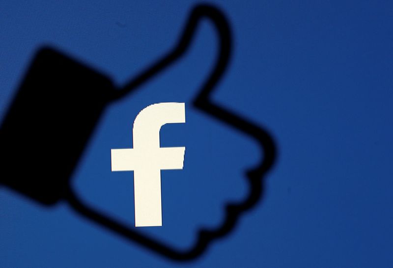 © Reuters. Il logo Facebook impresso sull'icona di un 'like'. REUTERS/Dado Ruvic