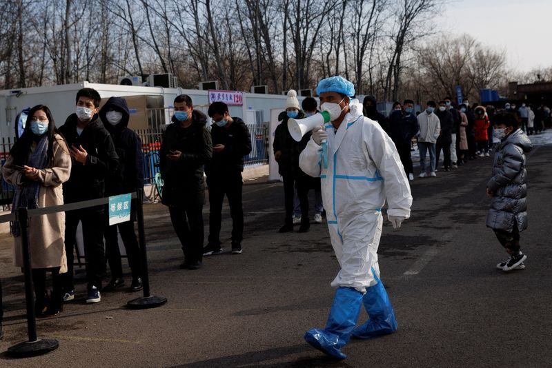 &copy; Reuters. Funcionário com traje de proteção instrui pessoas em fila em centro de testagem contra Covid-19 em Pequim
26/01/2022 REUTERS/Thomas Peter