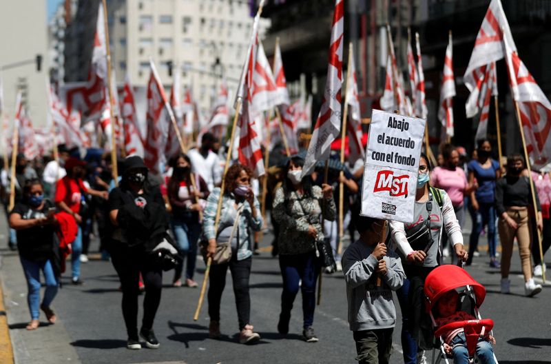 &copy; Reuters. Demonstrators holds placards that read slogans in opposition to the IMF, during a protest against the government's negotiations with the international financial institution near the Buenos Aires Obelisk, Argentina January 27, 2022. REUTERS/Agustin Marcari