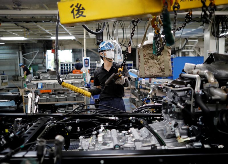 &copy; Reuters. FILE PHOTO: An employee wearing a protective face mask and face guard works on the automobile assembly line at Kawasaki factory of Mitsubishi Fuso Truck and Bus Corp, owned by Germany-based Daimler AG, in Kawasaki, south of Tokyo, Japan May 18, 2020. REUT