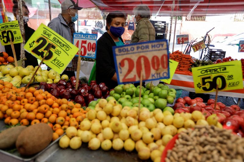 &copy; Reuters. FILE PHOTO: Customers walk past a fruit stall at a street market, in Mexico City, Mexico December 17, 2021. REUTERS/Luis Cortes/File Photo