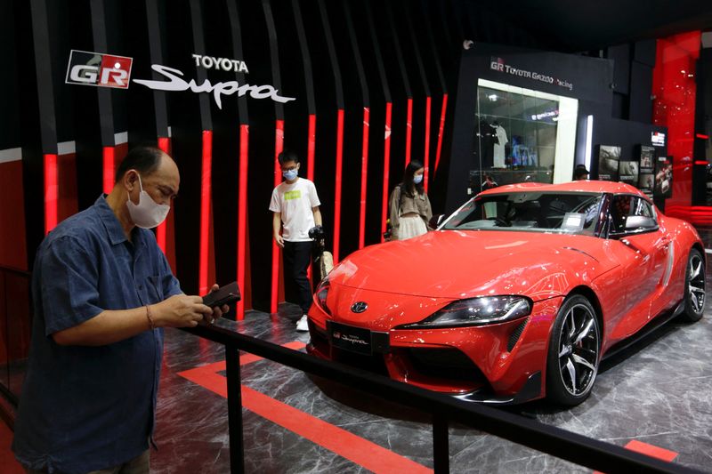 © Reuters. FILE PHOTO: People stand near a Toyota GR Supra at the Indonesia International Auto Show in Tangerang, near Jakarta, Indonesia, November 12, 2021. REUTERS/Ajeng Dinar Ulfiana