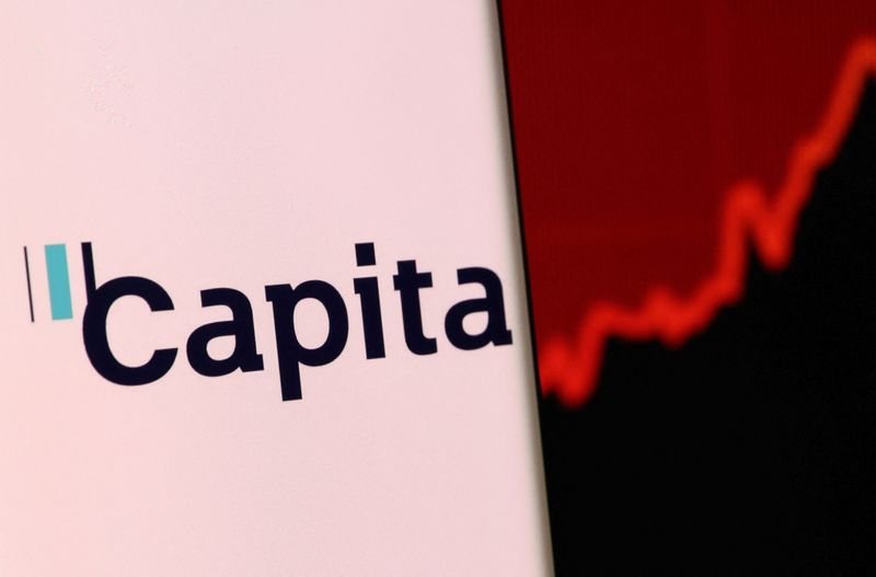 &copy; Reuters. FILE PHOTO: Capita's logo is pictured on a smartphone in front of an electronic display showing stock graph in this illustration taken, December 4, 2021. REUTERS/Dado Ruvic/Illustration