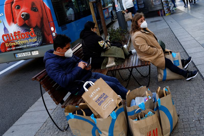 &copy; Reuters. FILE PHOTO: People sit next to shopping bags during winter sales in Madrid, Spain, January 11, 2022. REUTERS/Susana Vera