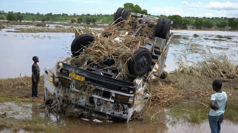 &copy; Reuters. Imagen de archivo de locales viendo los restos de un camión arrastrado por el agua durante la tormenta tropical Ana en el inundado río Shire, una desembocadura del lago Malaui, en la aldea de Thabwa, distrito Chikwawa, sur de Malaui. 26 de enero, 2022. 
