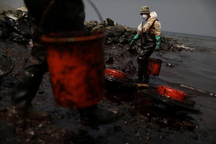 &copy; Reuters. Imagen de archivo de trabajadores limpiando un derrame de crudo en Ancón, Perú.