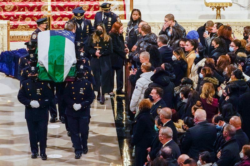 &copy; Reuters. Dominique Rivera, wife of New York City Police Department (NYPD) officer Jason Rivera, walks behind her husband's casket holding a cross after his funeral mass at St. Patrick's Cathedral in the Manhattan borough of New York City, U.S., January 28, 2022. M