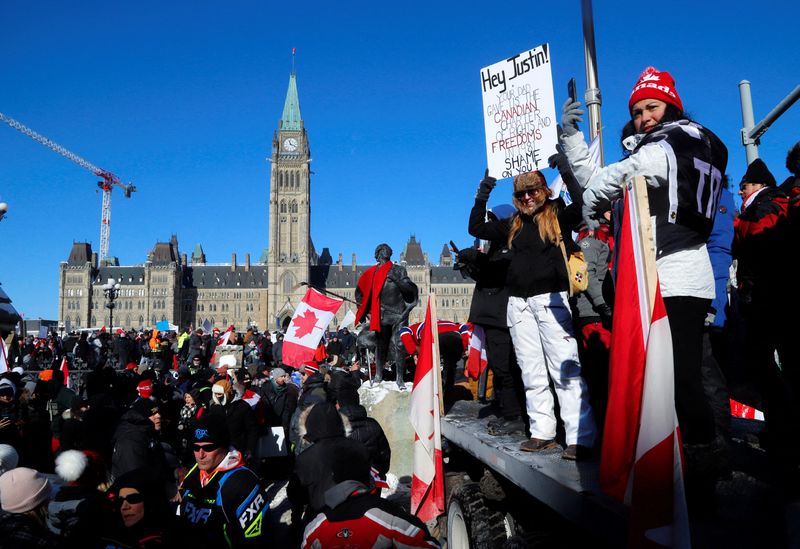 &copy; Reuters. Protestors stand in front of the Parliament Buildings as truckers take part in a convoy to protest coronavirus disease (COVID-19) vaccine mandates for cross-border truck drivers in Ottawa, Ontario, Canada, January 29, 2022.  REUTERS/Patrick Doyle